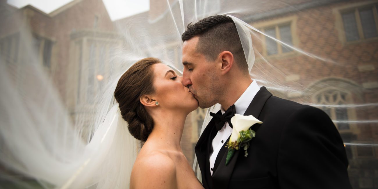 Bride and Groom share a kiss under the wedding veil at Meadow Brook Hall