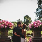Bride and Groom kiss along loggia terrace at Meadow Brook Hall.