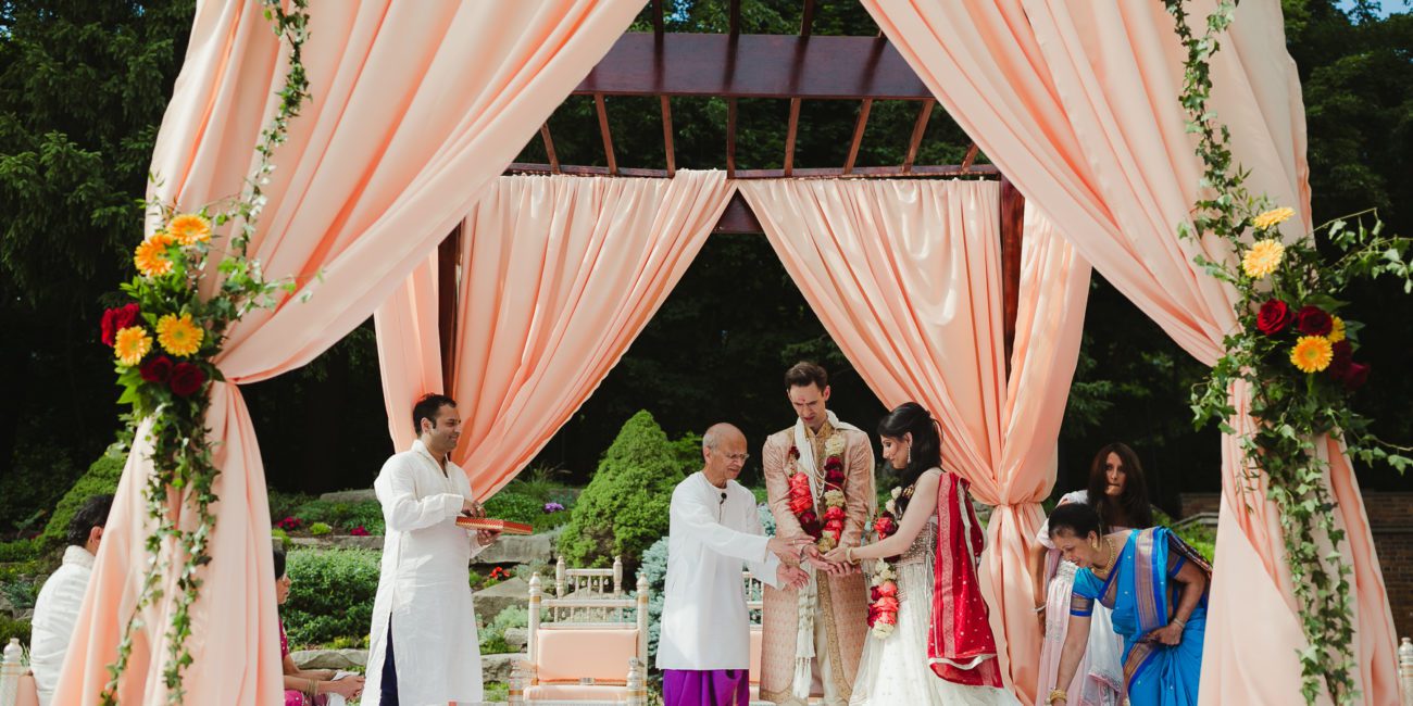Couple exchanges vows in Indian wedding ceremony.