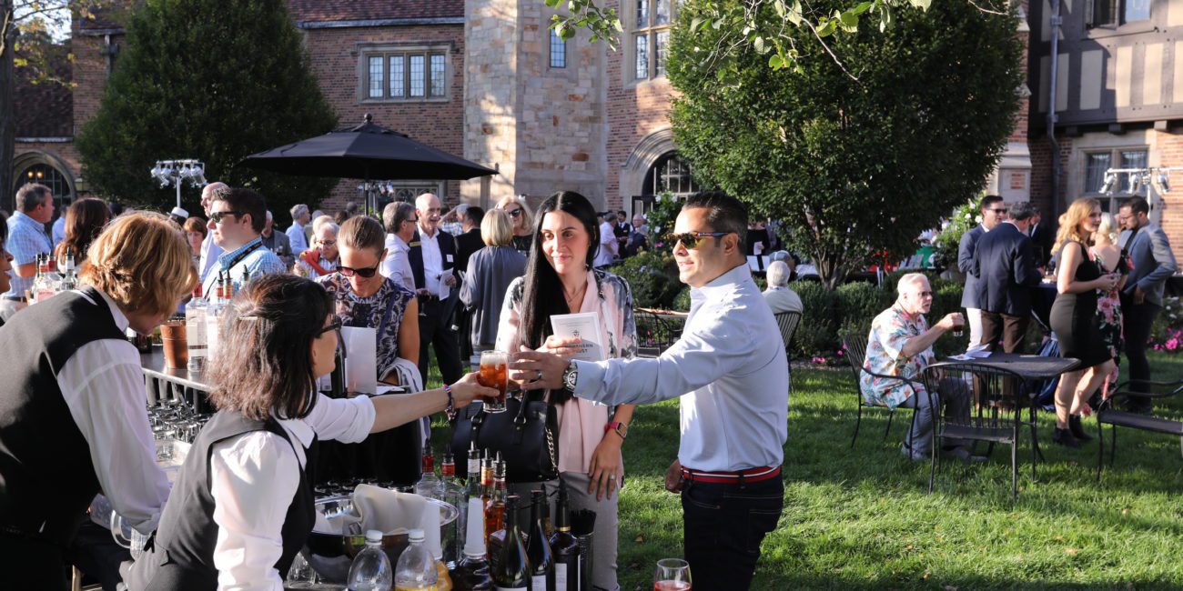 Guests partake in a bar set outside Meadow Brook Hall, along the loggia.