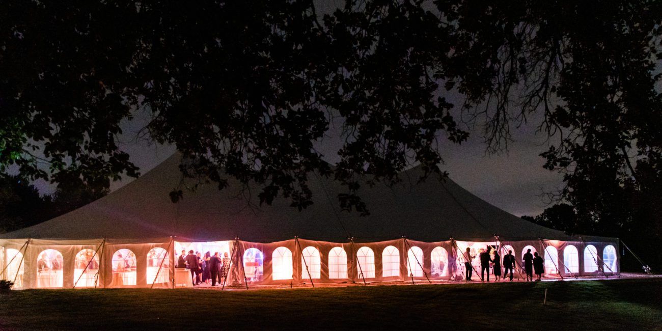 Meadow Brook Hall's Garden Tent lit up in colors for a summer wedding at night