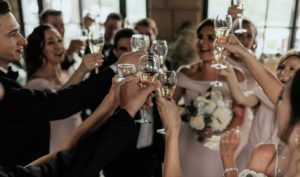 Wedding party clinks glasses for a toast at Meadow Brook Hall