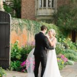 Bride and Groom kiss along the blooming wall garden at Meadow brook Hall