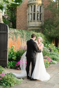Bride and Groom kiss along the blooming wall garden at Meadow brook Hall