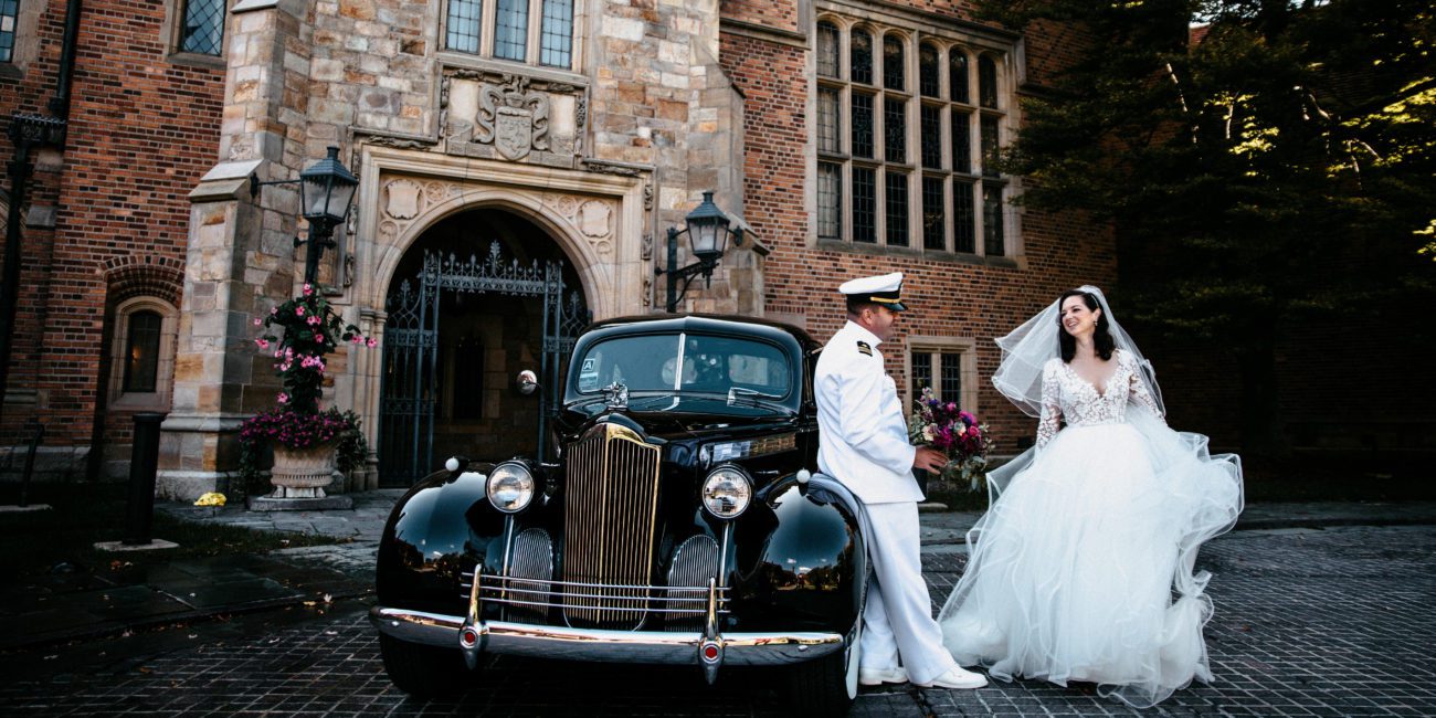 Bride and Groom in naval uniform greet each other outside Meadow Brook Hall.