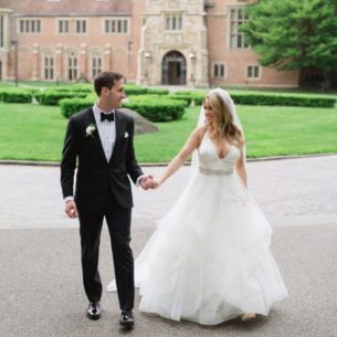 Bride and Groom hold hands outside of Meadow Brook Hall in summer.