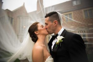 Couple kiss beneath the bride's veil at Meadow Brook Hall