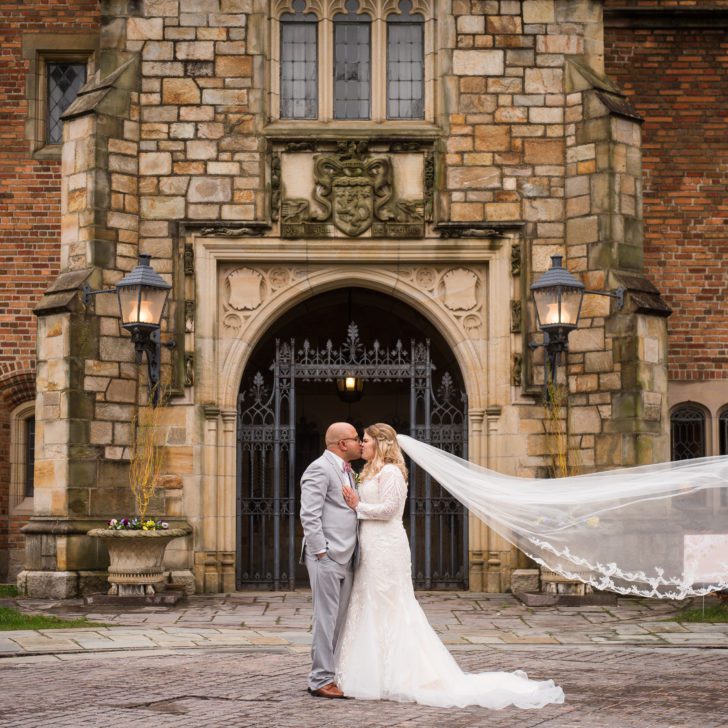 Couple poses in front of Meadow Brook's front gates on their wedding day