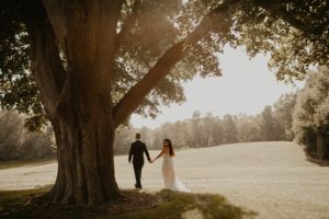 Bride and groom hold hands on wedding day at Meadow Brook Hall