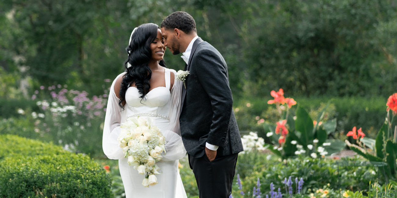 Bride and groom kiss in the gardens at Meadow Brook Hall on their wedding day
