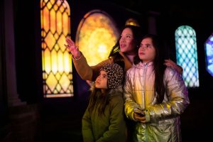 People looking up at holiday lights at Meadow Brook Hall